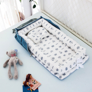 Réducteur de lit pour bébé bleu avec motifs posé sur un lit avec des jouets et un doudou