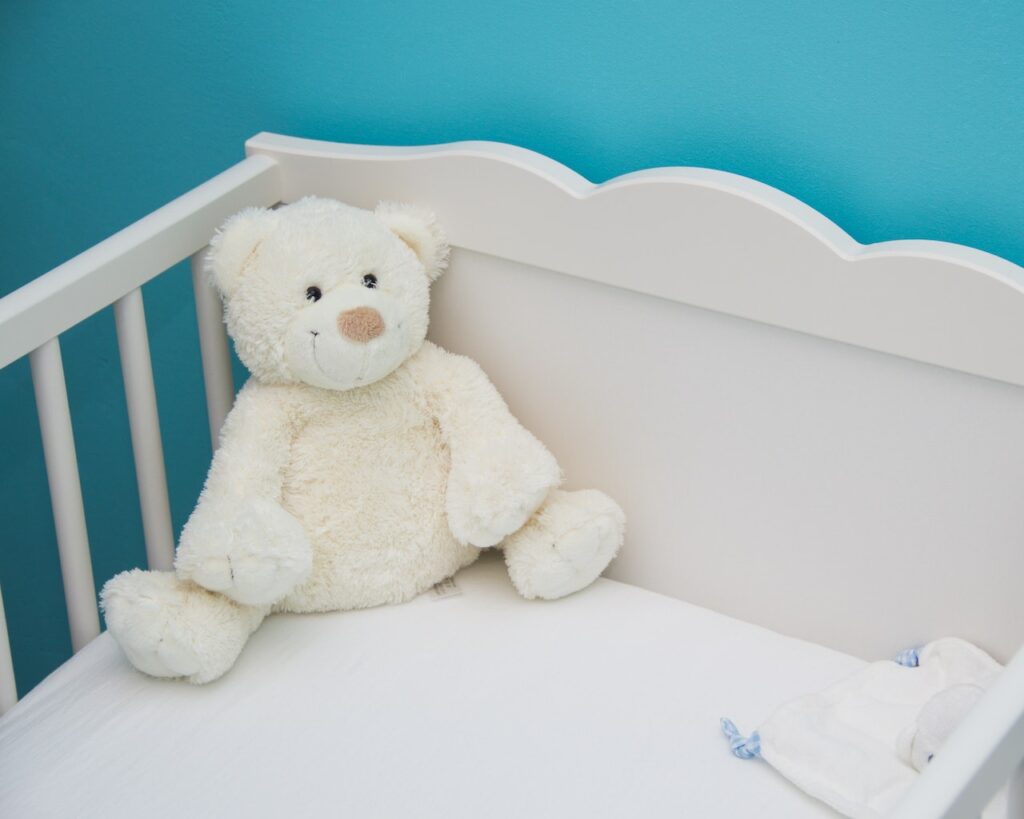 une magnifique peluche ours blanc dans le lit de bébé : un incontournable